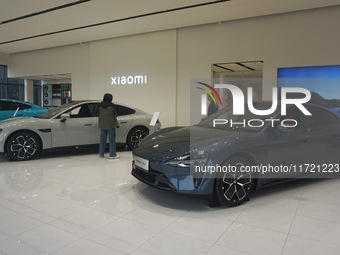 Customers buy a Xiaomi SU7 new energy vehicle at a Xiaomi Auto store in Hangzhou, China, on October 30, 2024. (