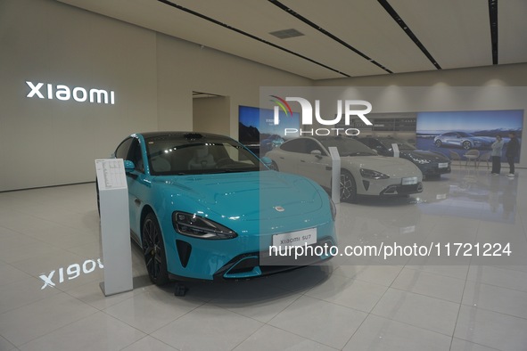 Customers buy a Xiaomi SU7 new energy vehicle at a Xiaomi Auto store in Hangzhou, China, on October 30, 2024. 