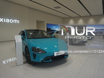 Customers buy a Xiaomi SU7 new energy vehicle at a Xiaomi Auto store in Hangzhou, China, on October 30, 2024. (