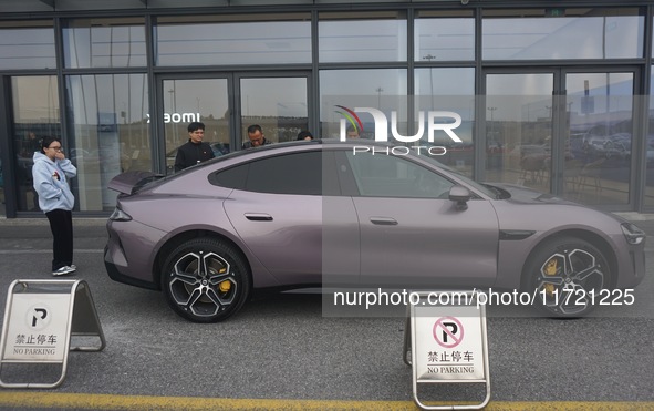 Customers buy a Xiaomi SU7 new energy vehicle at a Xiaomi Auto store in Hangzhou, China, on October 30, 2024. 