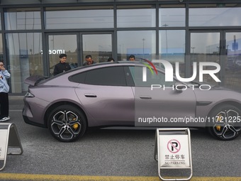 Customers buy a Xiaomi SU7 new energy vehicle at a Xiaomi Auto store in Hangzhou, China, on October 30, 2024. (