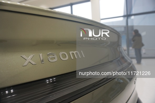 Customers buy a Xiaomi SU7 new energy vehicle at a Xiaomi Auto store in Hangzhou, China, on October 30, 2024. 