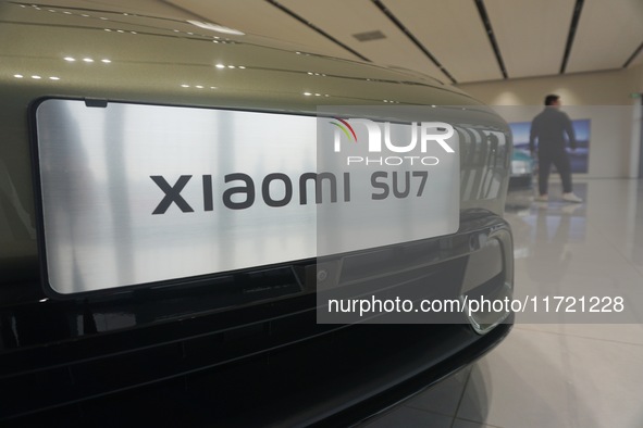 Customers buy a Xiaomi SU7 new energy vehicle at a Xiaomi Auto store in Hangzhou, China, on October 30, 2024. 