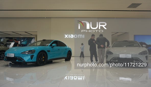 Customers buy a Xiaomi SU7 new energy vehicle at a Xiaomi Auto store in Hangzhou, China, on October 30, 2024. 