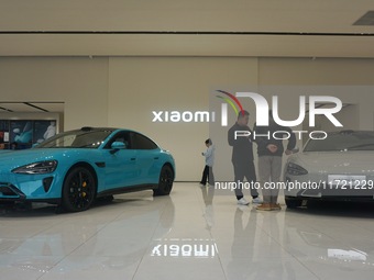 Customers buy a Xiaomi SU7 new energy vehicle at a Xiaomi Auto store in Hangzhou, China, on October 30, 2024. (