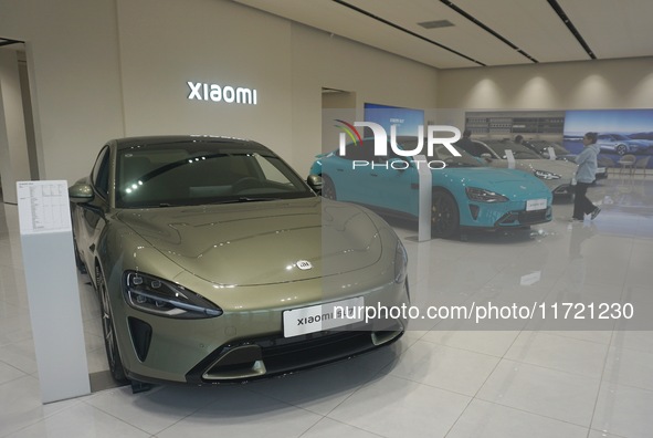 Customers buy a Xiaomi SU7 new energy vehicle at a Xiaomi Auto store in Hangzhou, China, on October 30, 2024. 