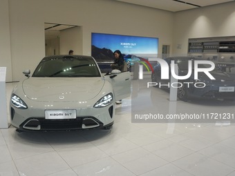 Customers buy a Xiaomi SU7 new energy vehicle at a Xiaomi Auto store in Hangzhou, China, on October 30, 2024. (