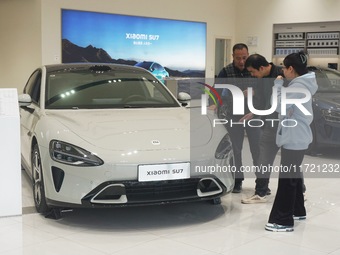 Customers buy a Xiaomi SU7 new energy vehicle at a Xiaomi Auto store in Hangzhou, China, on October 30, 2024. (