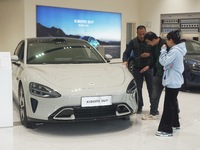 Customers buy a Xiaomi SU7 new energy vehicle at a Xiaomi Auto store in Hangzhou, China, on October 30, 2024. (