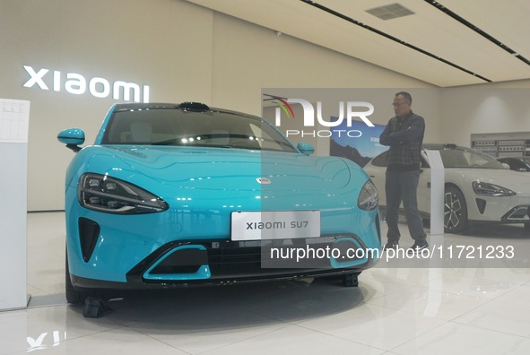 Customers buy a Xiaomi SU7 new energy vehicle at a Xiaomi Auto store in Hangzhou, China, on October 30, 2024. 