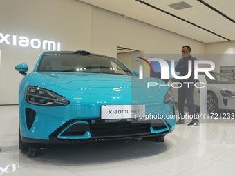 Customers buy a Xiaomi SU7 new energy vehicle at a Xiaomi Auto store in Hangzhou, China, on October 30, 2024. (