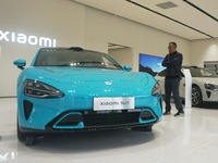 Customers buy a Xiaomi SU7 new energy vehicle at a Xiaomi Auto store in Hangzhou, China, on October 30, 2024. (