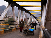 People walk on a cold morning over a bridge in Baramulla, Jammu and Kashmir, India, on October 29, 2024. (