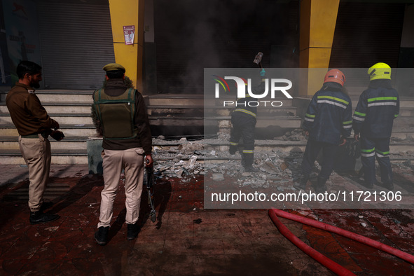 Firefighters try to douse the flames after a fire incident is reported in a commercial building in Srinagar, Jammu and Kashmir, India, on Oc...