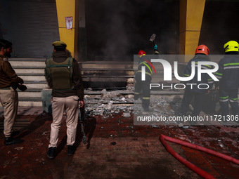 Firefighters try to douse the flames after a fire incident is reported in a commercial building in Srinagar, Jammu and Kashmir, India, on Oc...