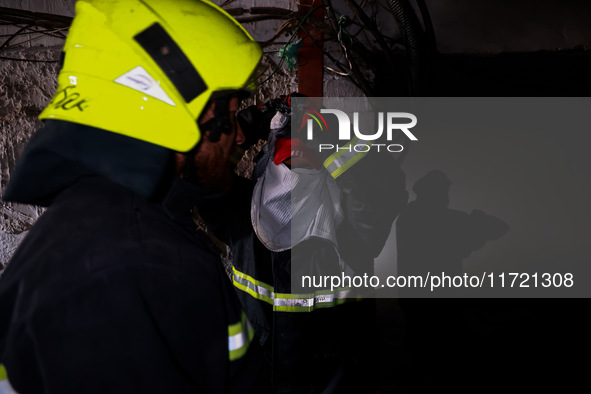 Firefighters try to douse the flames after a fire incident is reported in a commercial building in Srinagar, Jammu and Kashmir, India, on Oc...