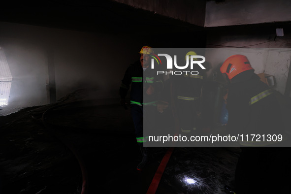 Firefighters try to douse the flames after a fire incident is reported in a commercial building in Srinagar, Jammu and Kashmir, India, on Oc...