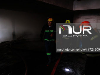 Firefighters try to douse the flames after a fire incident is reported in a commercial building in Srinagar, Jammu and Kashmir, India, on Oc...