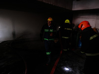 Firefighters try to douse the flames after a fire incident is reported in a commercial building in Srinagar, Jammu and Kashmir, India, on Oc...