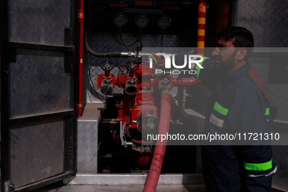 Firefighters try to douse the flames after a fire incident is reported in a commercial building in Srinagar, Jammu and Kashmir, India, on Oc...