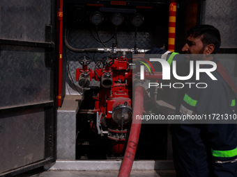 Firefighters try to douse the flames after a fire incident is reported in a commercial building in Srinagar, Jammu and Kashmir, India, on Oc...