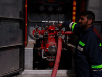 Firefighters try to douse the flames after a fire incident is reported in a commercial building in Srinagar, Jammu and Kashmir, India, on Oc...