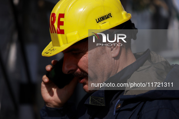 Firefighters try to douse the flames after a fire incident is reported in a commercial building in Srinagar, Jammu and Kashmir, India, on Oc...