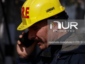 Firefighters try to douse the flames after a fire incident is reported in a commercial building in Srinagar, Jammu and Kashmir, India, on Oc...