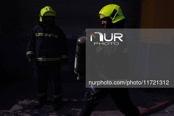 Firefighters try to douse the flames after a fire incident is reported in a commercial building in Srinagar, Jammu and Kashmir, India, on Oc...