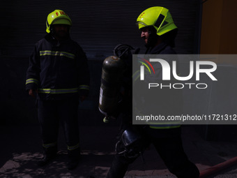 Firefighters try to douse the flames after a fire incident is reported in a commercial building in Srinagar, Jammu and Kashmir, India, on Oc...