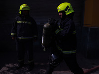 Firefighters try to douse the flames after a fire incident is reported in a commercial building in Srinagar, Jammu and Kashmir, India, on Oc...