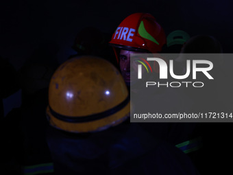 Firefighters try to douse the flames after a fire incident is reported in a commercial building in Srinagar, Jammu and Kashmir, India, on Oc...