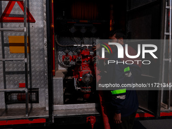 Firefighters try to douse the flames after a fire incident is reported in a commercial building in Srinagar, Jammu and Kashmir, India, on Oc...