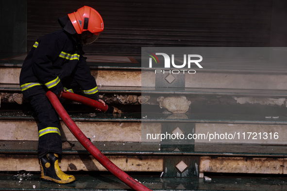 Firefighters try to douse the flames after a fire incident is reported in a commercial building in Srinagar, Jammu and Kashmir, India, on Oc...