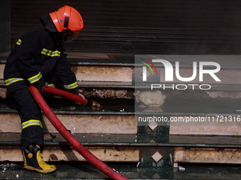 Firefighters try to douse the flames after a fire incident is reported in a commercial building in Srinagar, Jammu and Kashmir, India, on Oc...