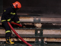 Firefighters try to douse the flames after a fire incident is reported in a commercial building in Srinagar, Jammu and Kashmir, India, on Oc...