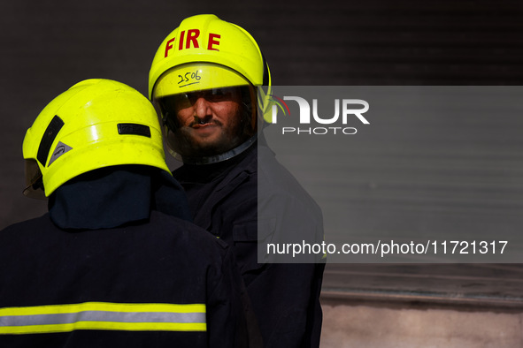 Firefighters try to douse the flames after a fire incident is reported in a commercial building in Srinagar, Jammu and Kashmir, India, on Oc...