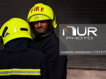 Firefighters try to douse the flames after a fire incident is reported in a commercial building in Srinagar, Jammu and Kashmir, India, on Oc...