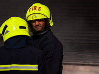 Firefighters try to douse the flames after a fire incident is reported in a commercial building in Srinagar, Jammu and Kashmir, India, on Oc...