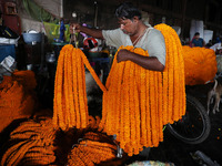 A laborer unloads garlands of marigold flowers at a wholesale flower market, which are used to decorate temples and homes, ahead of the Diwa...