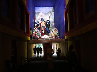 People walk under a ''pandal'' (a temporary platform), a decorated structure, under a huge clay idol of the Hindu goddess Kali, ahead of the...