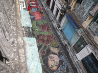 People walk on the graffiti-painted road in front of a ''pandal'' (a temporary platform), a decorated structure, ahead of the Kali Puja fest...