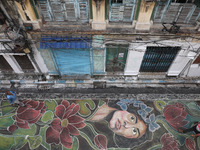 People walk on the graffiti-painted road in front of a ''pandal'' (a temporary platform), a decorated structure, ahead of the Kali Puja fest...