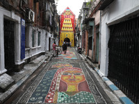 People walk on the graffiti-painted road in front of a ''pandal'' (a temporary platform), a decorated structure, ahead of the Kali Puja fest...