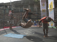 Children jump on a trampoline at a fair outside a ''pandal,'' a decorated temporary platform, ahead of the Kali Puja festival in Kolkata, In...