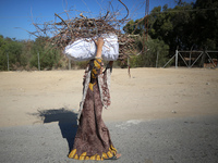 A woman carries firewood and walks along a street in Khan Yunis, Gaza Strip, on October 30, 2024, amid the ongoing conflict between Israel a...