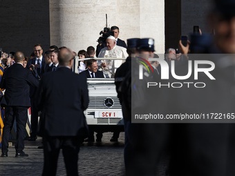 Pope Francis waves to the crowd from the popemobile as he arrives for the weekly general audience at Saint Peter's Square in The Vatican on...