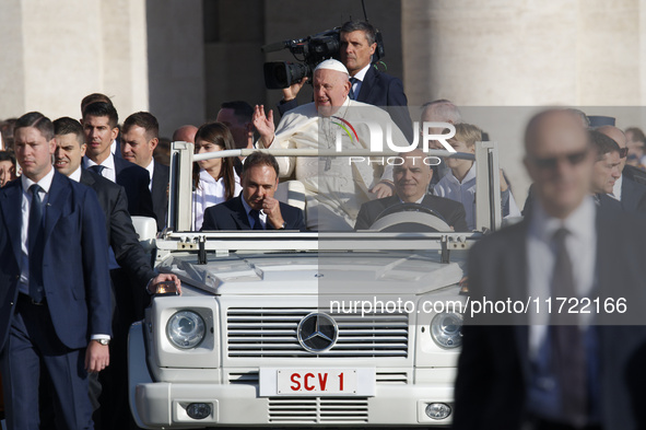 Pope Francis waves to the crowd from the popemobile as he arrives for the weekly general audience at Saint Peter's Square in The Vatican on...