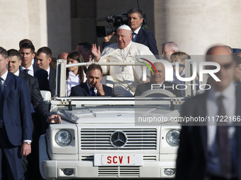 Pope Francis waves to the crowd from the popemobile as he arrives for the weekly general audience at Saint Peter's Square in The Vatican on...