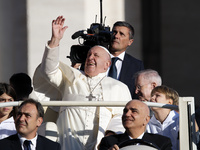 Pope Francis looks up from the popemobile as he arrives for the weekly general audience at Saint Peter's Square in The Vatican on October 30...